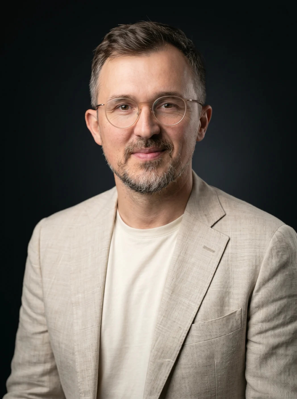 Pierre Blanquett, founder of sentiention, in a light linen jacket against a dark studio ground.